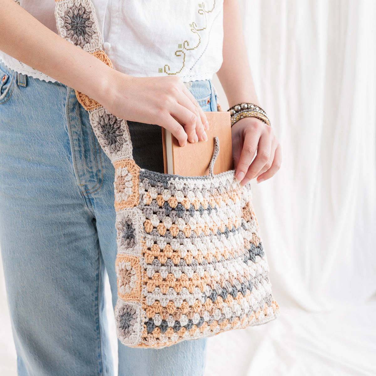Crochet Tie Top Tote made using Caron yarn in a styled lifestyle setting
