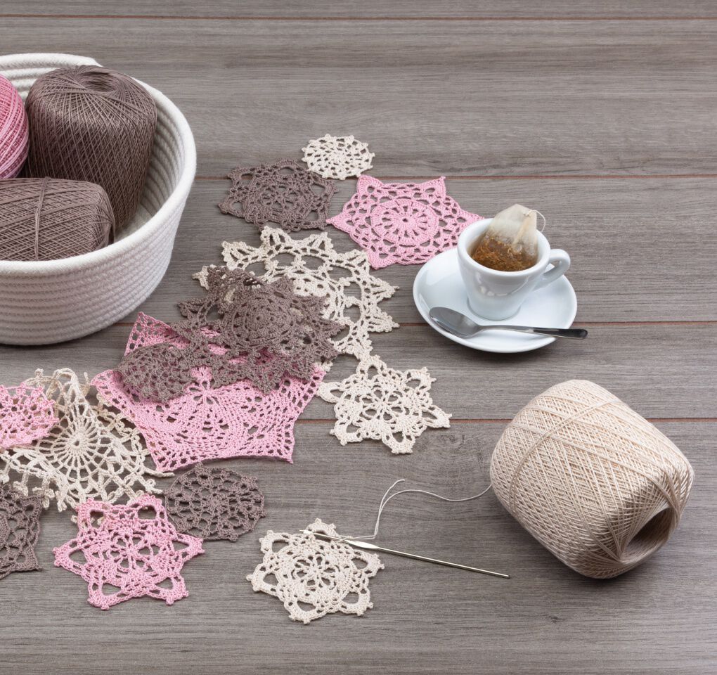 Crochet snowflakes in pink, cream, and brown