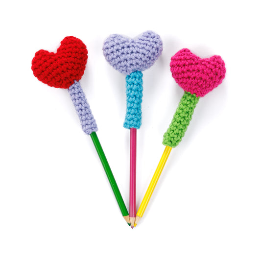 Crochet Heart Pencil Toppers made using Red Heart yarn on a white background
