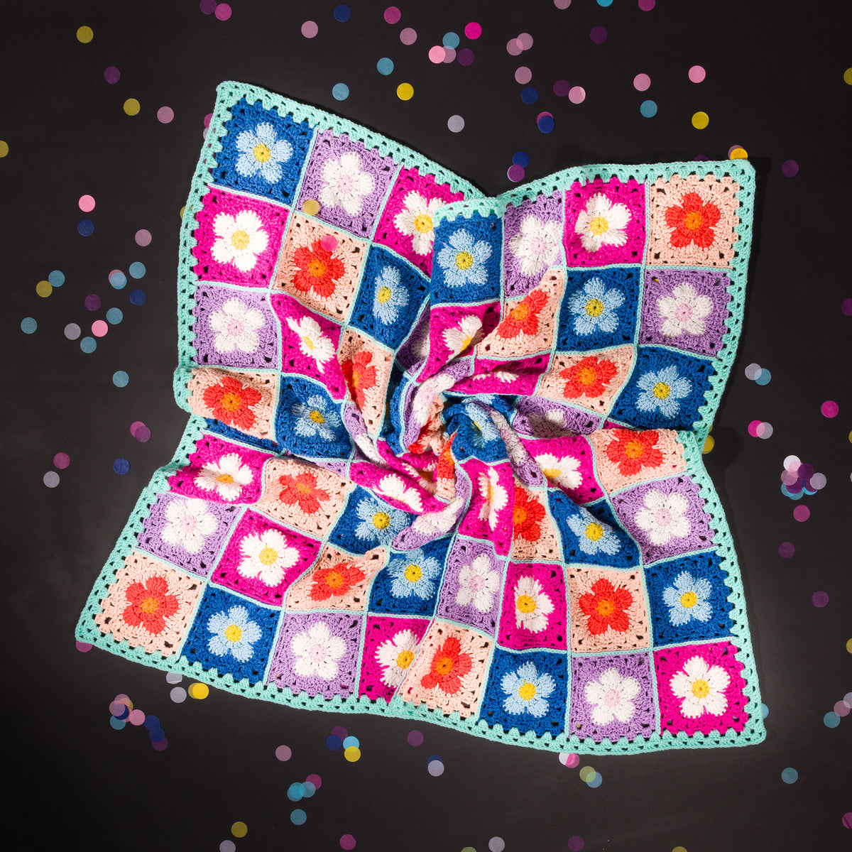 A crocheted blanket with a colorful floral pattern made using Red Heart All in One Flower Power yarn, Version 2